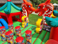 Piepūšamo atrakciju noma. Pūķu parks Piepūšamā atrakcija ar diviem sarkaniem pūķiem